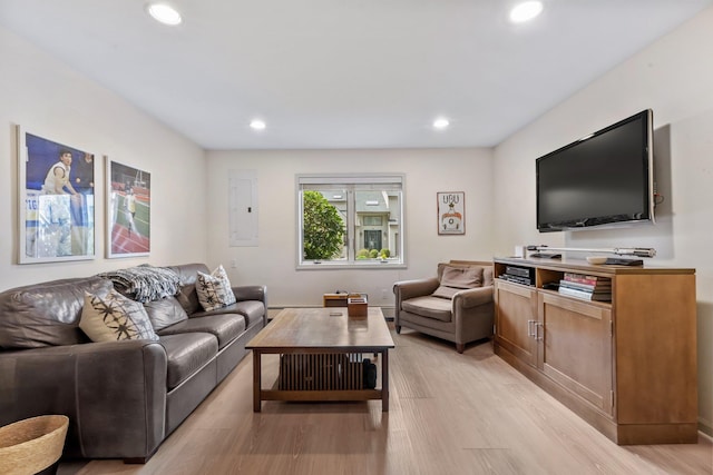 living room with recessed lighting, electric panel, and light wood-style flooring