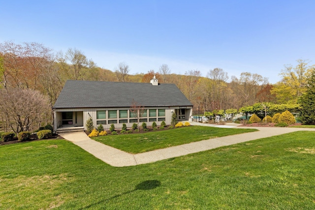 view of front of property featuring a front yard and a chimney
