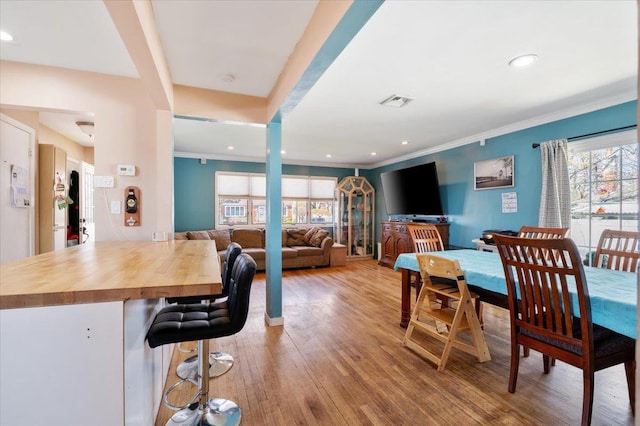 dining space with visible vents, crown molding, light wood-style flooring, and recessed lighting