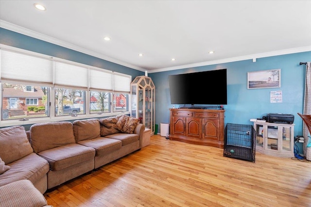 living room featuring light wood-style floors, crown molding, and recessed lighting