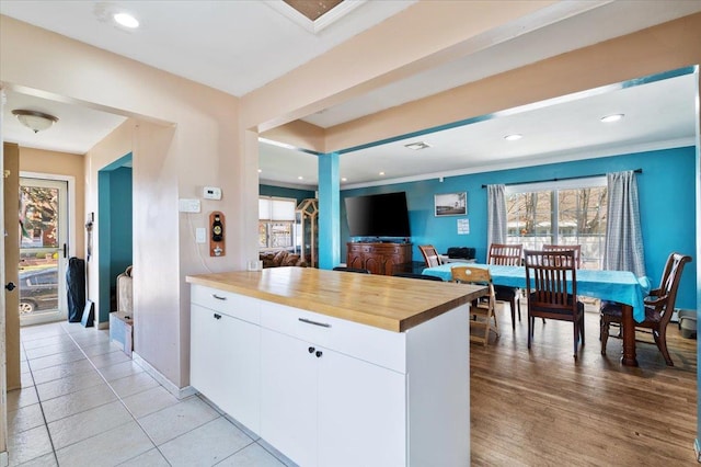 kitchen with white cabinetry, butcher block countertops, plenty of natural light, and crown molding