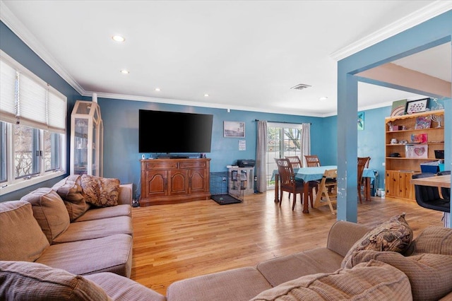 living area featuring recessed lighting, light wood-style floors, and crown molding
