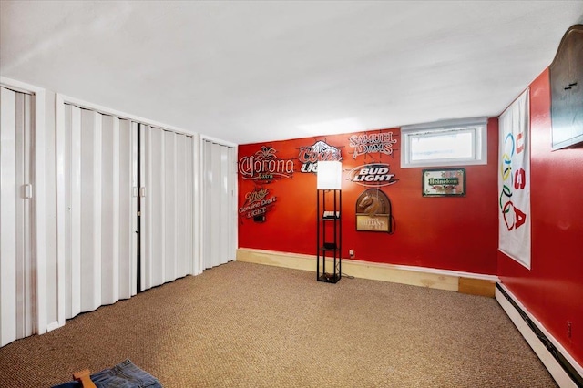 interior space with a baseboard heating unit and carpet floors