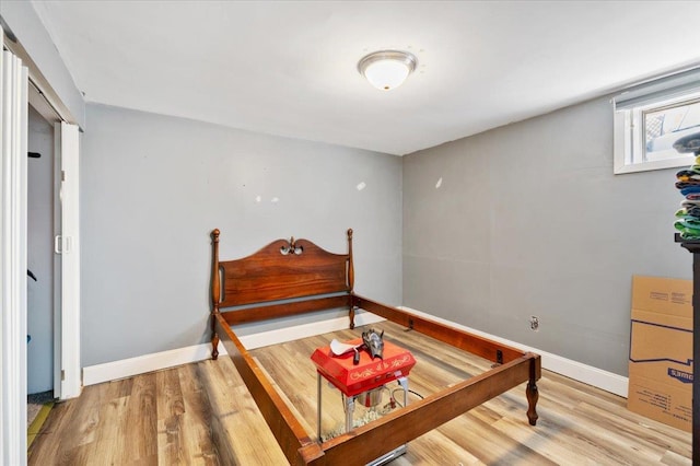 bedroom with wood finished floors and baseboards