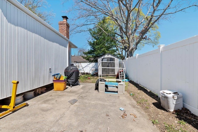 view of patio featuring an outdoor structure, a shed, and a fenced backyard