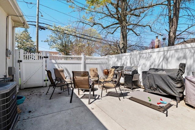 view of patio / terrace with a gate, a fenced backyard, and central AC