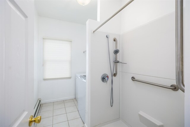 bathroom with baseboard heating, tile patterned flooring, tiled shower, and washer / clothes dryer