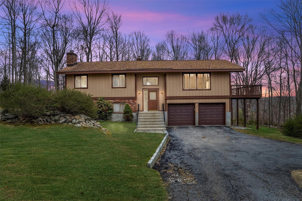 3 Raymond Rd, North Salem, NY 10560 - raised ranch featuring roof with shingles, a front lawn, a chimney, an attached garage, and aphalt driveway