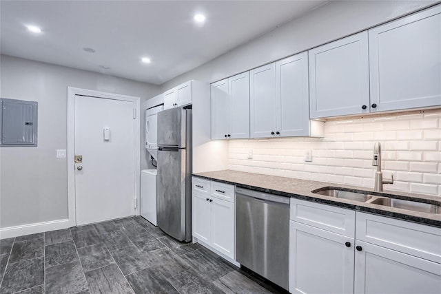 kitchen with dark stone countertops, a sink, electric panel, stainless steel appliances, and white cabinetry
