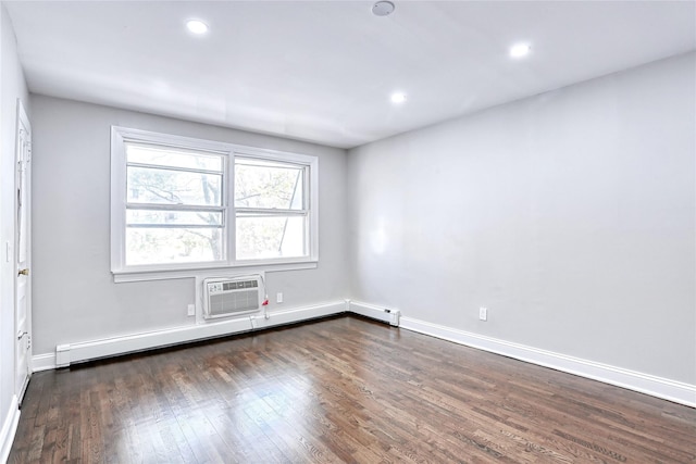 spare room featuring a baseboard radiator, baseboards, dark wood-type flooring, and recessed lighting