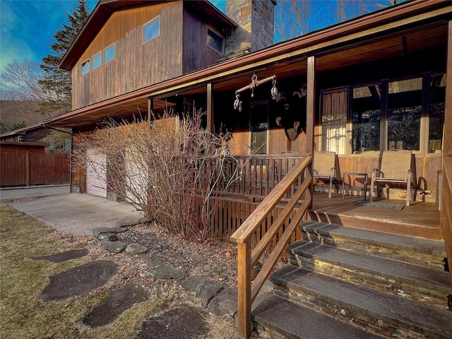 property entrance featuring a chimney and covered porch