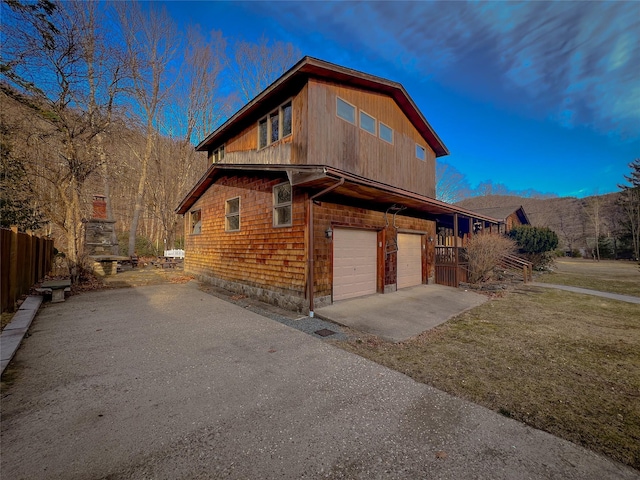view of home's exterior with a garage, aphalt driveway, and fence