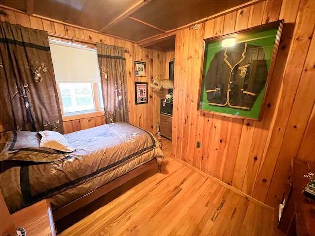 bedroom featuring wood finished floors and wooden walls