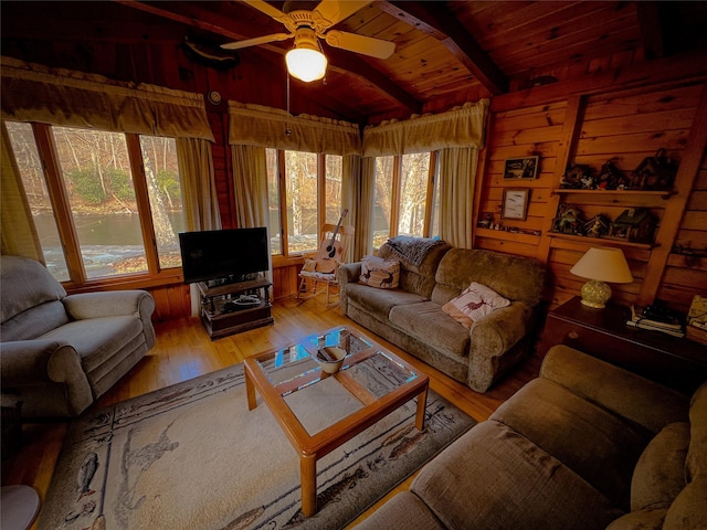 living room featuring hardwood / wood-style floors, wooden walls, vaulted ceiling with beams, wooden ceiling, and ceiling fan