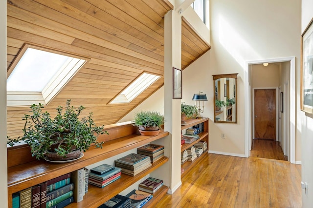 20 Schoolhouse Rd, Waccabuc, NY 10597 - hall featuring baseboards, vaulted ceiling with skylight, and hardwood / wood-style floors