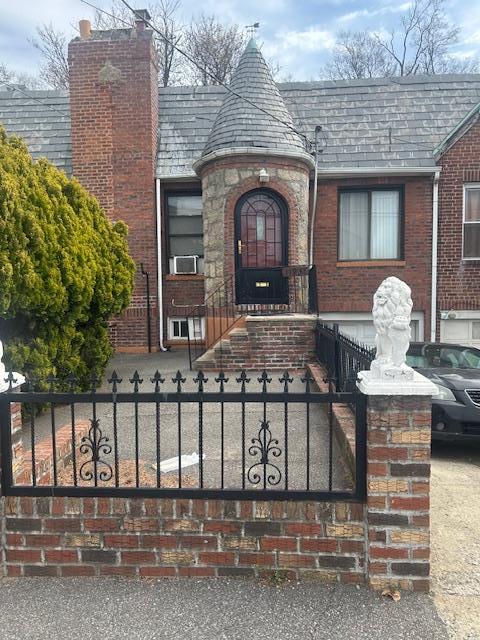 property entrance featuring brick siding, cooling unit, a chimney, and fence