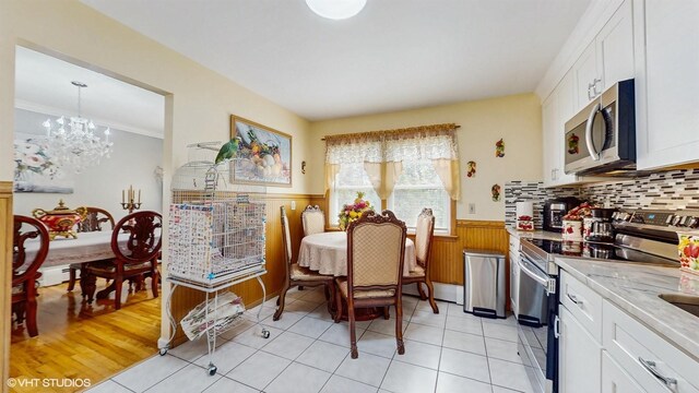 754 Wolcott Ave, Beacon, NY 12508 - kitchen featuring white cabinets, appliances with stainless steel finishes, a notable chandelier, and wainscoting