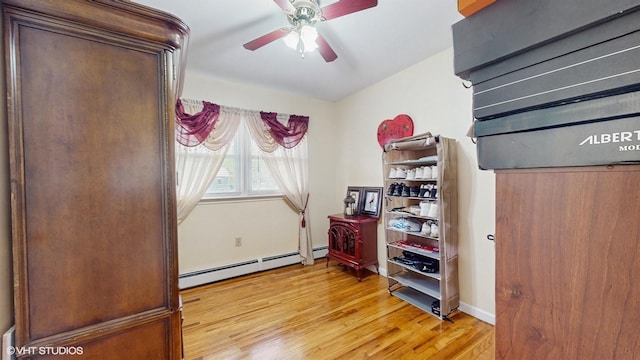 754 Wolcott Ave, Beacon, NY 12508 - bedroom with a baseboard heating unit, ceiling fan, baseboards, and light wood-style floors