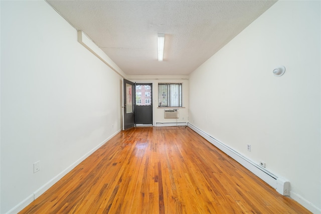 140-44 34th Ave Unit 4C, Flushing, NY 11354 - spare room featuring wood finished floors, baseboard heating, baseboards, and a wall mounted AC
