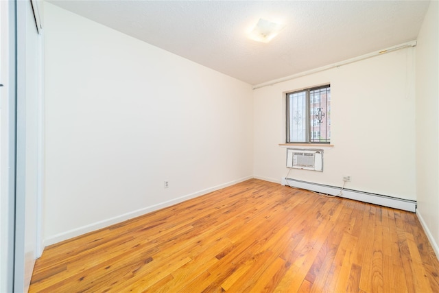140-44 34th Ave Unit 4C, Flushing, NY 11354 - empty room with baseboard heating, a wall mounted air conditioner, light wood finished floors, and baseboards