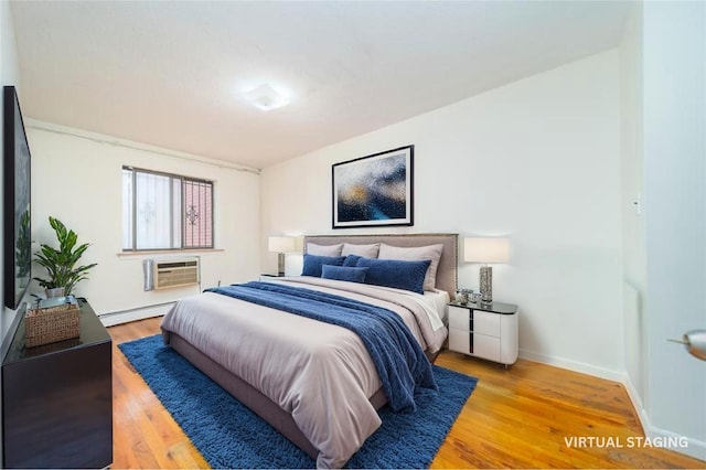 140-44 34th Ave Unit 4C, Flushing, NY 11354 - bedroom featuring a baseboard radiator, wood finished floors, baseboards, and a wall unit AC