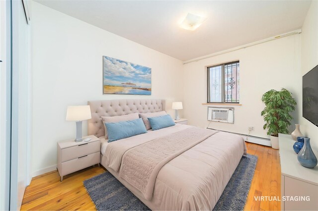 140-44 34th Ave Unit 4C, Flushing, NY 11354 - bedroom with baseboard heating, a wall unit AC, light wood-type flooring, and baseboards