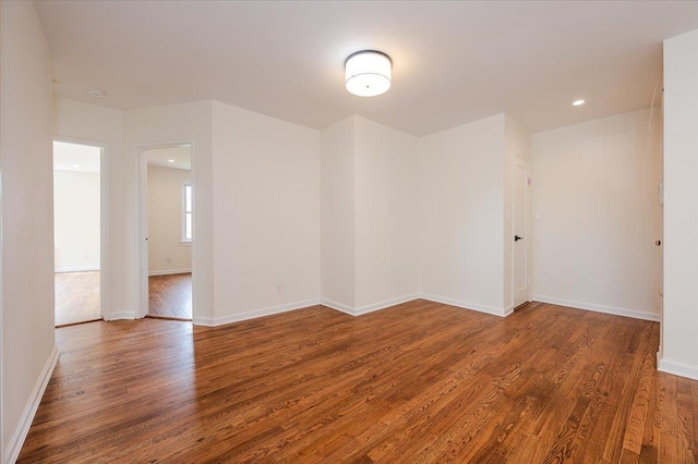 spare room with wood finished floors and baseboards