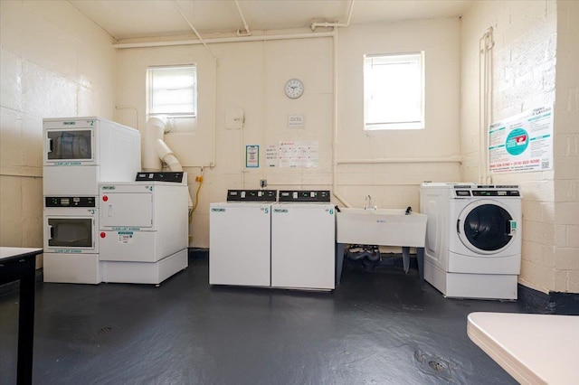 shared laundry with separate washer and dryer and concrete block wall