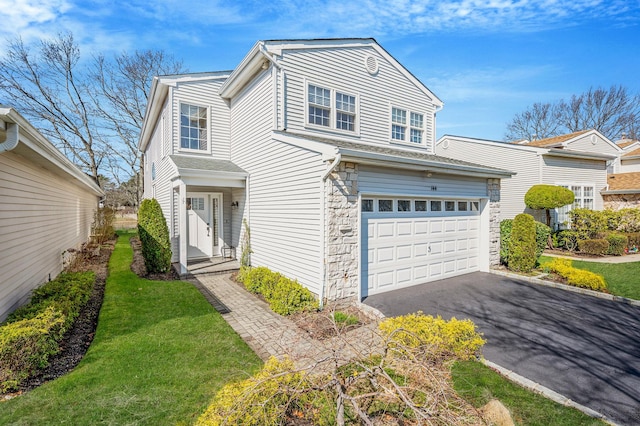 view of front facade with an attached garage, driveway, and stone siding