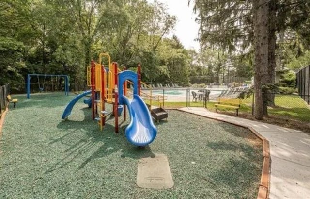 community jungle gym with fence and a yard