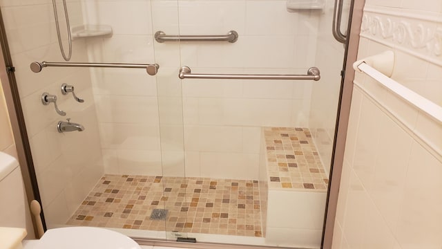 bathroom featuring a stall shower and toilet