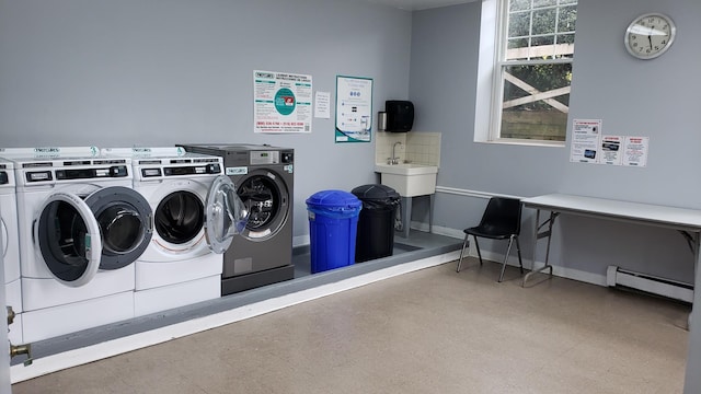 community laundry room featuring a baseboard radiator, independent washer and dryer, and baseboards