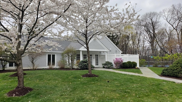 view of front of home featuring fence and a front lawn