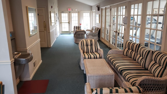 living area with lofted ceiling, french doors, and carpet flooring