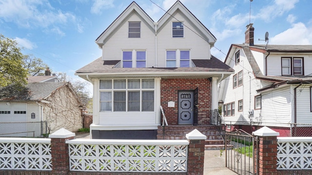 9920 196th St, Hollis, NY 11423 - view of front of home with a gate, brick siding, a shingled roof, and a fenced front yard