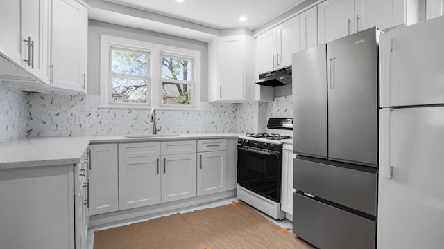 9920 196th St, Hollis, NY 11423 - kitchen featuring gas stove, freestanding refrigerator, under cabinet range hood, and a sink