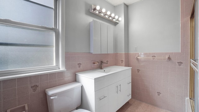 9920 196th St, Hollis, NY 11423 - bathroom with toilet, tile walls, tile patterned floors, vanity, and wainscoting