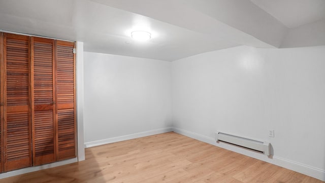 9920 196th St, Hollis, NY 11423 - unfurnished bedroom with baseboards, wood finished floors, a closet, and baseboard heating