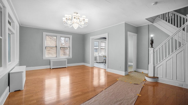 9920 196th St, Hollis, NY 11423 - unfurnished dining area with radiator, an inviting chandelier, wood finished floors, and ornamental molding