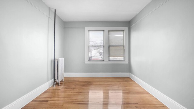 9920 196th St, Hollis, NY 11423 - spare room featuring baseboards, light wood-style flooring, and radiator