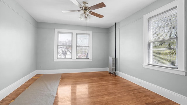 9920 196th St, Hollis, NY 11423 - spare room with radiator, baseboards, wood finished floors, and ceiling fan
