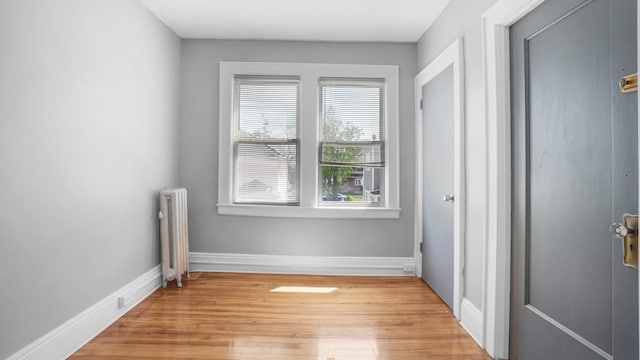 9920 196th St, Hollis, NY 11423 - unfurnished bedroom with baseboards, light wood finished floors, and radiator