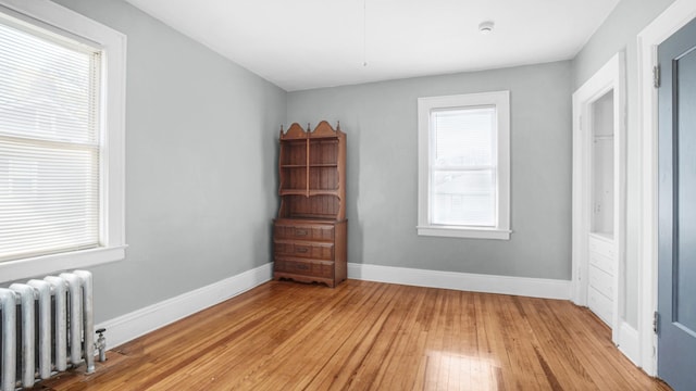 9920 196th St, Hollis, NY 11423 - bedroom with radiator heating unit, baseboards, and light wood-style flooring
