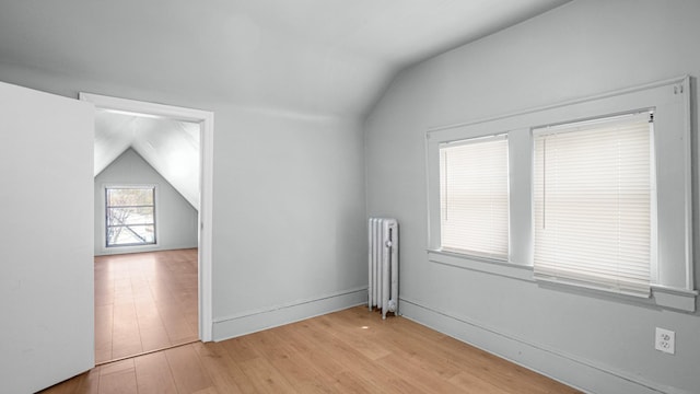 9920 196th St, Hollis, NY 11423 - additional living space with light wood-style floors, radiator heating unit, and lofted ceiling