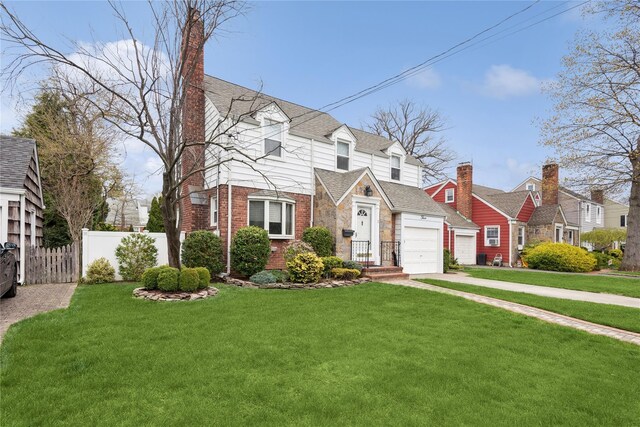 cape cod home featuring fence, a front lawn, brick siding, and a garage