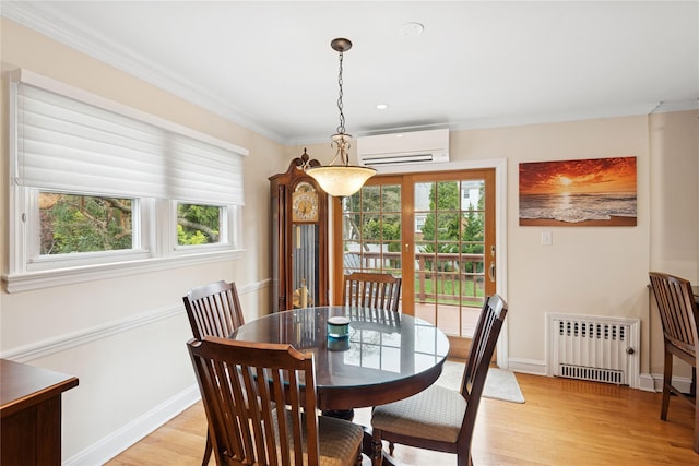 dining space with radiator, a wall unit AC, light wood-style floors, crown molding, and baseboards