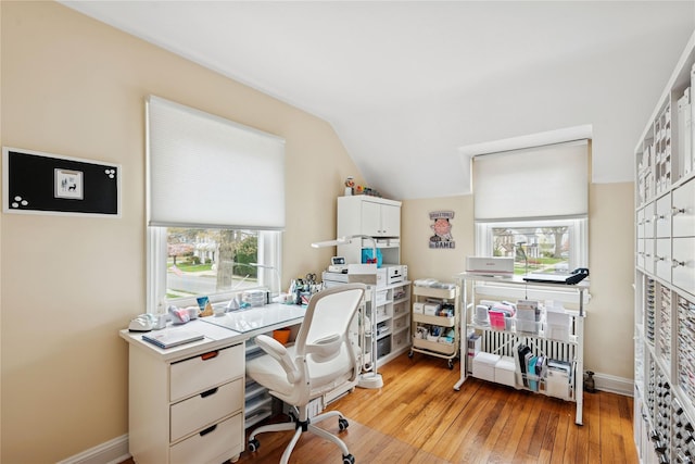 office area with lofted ceiling, baseboards, and light wood finished floors