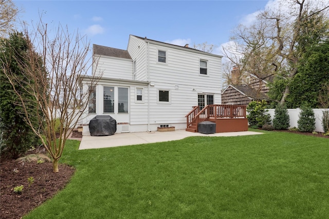 rear view of house featuring a yard, a wooden deck, fence, and a patio area