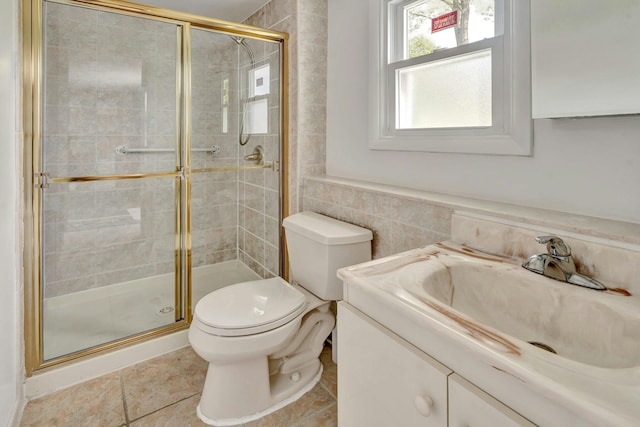 full bathroom with a shower stall, toilet, vanity, and tile walls