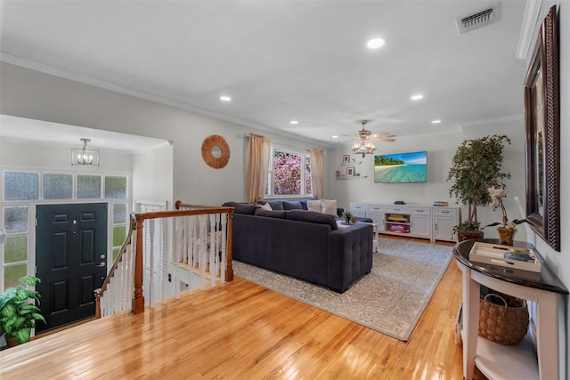 living room featuring ceiling fan with notable chandelier, hardwood / wood-style floors, recessed lighting, visible vents, and ornamental molding